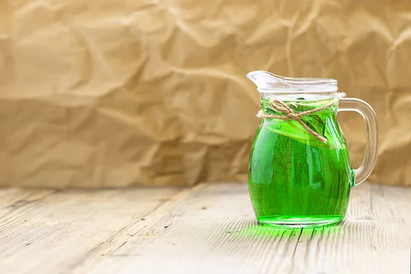 Sommer kaltes grünes Getränk aus Estragon, mit Minze und Zitronenscheiben im Glasdekanter. horizontal mit Kopierraum. Estragon Schaumgetränk. Limonade — Stockfoto