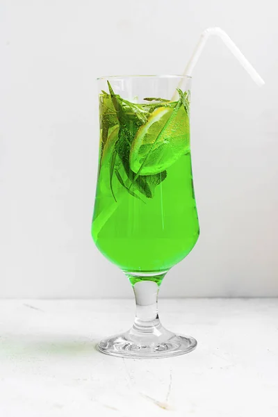 Θερινό κρύο πράσινο ποτό από εστραγκόν, με μέντα και φέτες λεμονιού σε ποτήρι με καλαμάκι σε ανοιχτό φόντο. Αφρώδες ποτό, λεμονάδα. Οριζόντια με χώρο αντιγραφής — Φωτογραφία Αρχείου