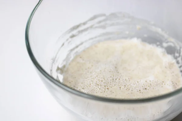 Pasta acida cruda pasta integrale per pane, prosazia di miscelazione pre-impasto in ciotola di vetro, impastare, orizzontale con spazio copia, messa a fuoco selettiva, cibo sano, nutriente. Fondo bianco — Foto Stock