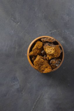 Vahşi Chaga Mantarı huş ağacının kabuğunda yaşar, Inonotus obquus ise koyu dokulu arka planda. Çay, organik sağlıklı içecek, doğal ilaç ve antioksidan yapımında kullanılıyor. Uzayı kopyala Yiyecek.