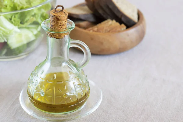 Ekstra saf zeytinyağı, güzel cam şişede, servis masasının üzerinde mantar, çözülmüş yeşil salata ve koyu ekmek. Kopya uzayı ile yatay. Evde yemek için hazırlık yapıyorum. Organik ürünler, Gıda