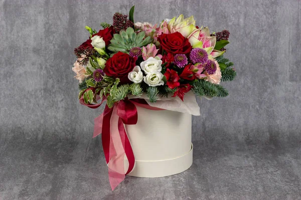 Fresh arrangement of bright flowers in a hat box florist work place for text — Stock Photo, Image