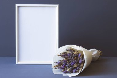 Kurumuş çiçeklerin bileşimi ve gri arkaplan fotokopi alanı üzerinde bir fotoğraf çerçevesi