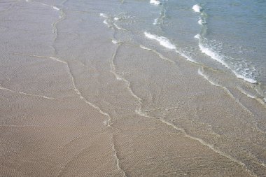 Kumlu sahilde denizin yumuşak dalgası.