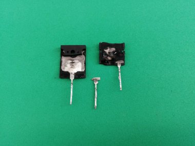 Yeşil zemin üzerinde eski bozuk bipolar transistör