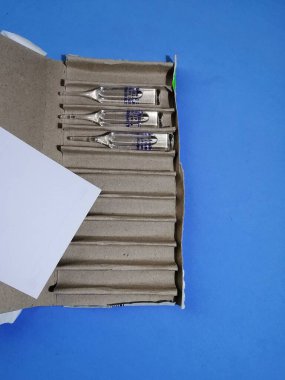 Misk Belarus Cumhuriyeti Mart 2020 cam enjeksiyon ampulleri bir kağıt kutu içinde boş bir sayfa mavi bir yüzey üzerinde