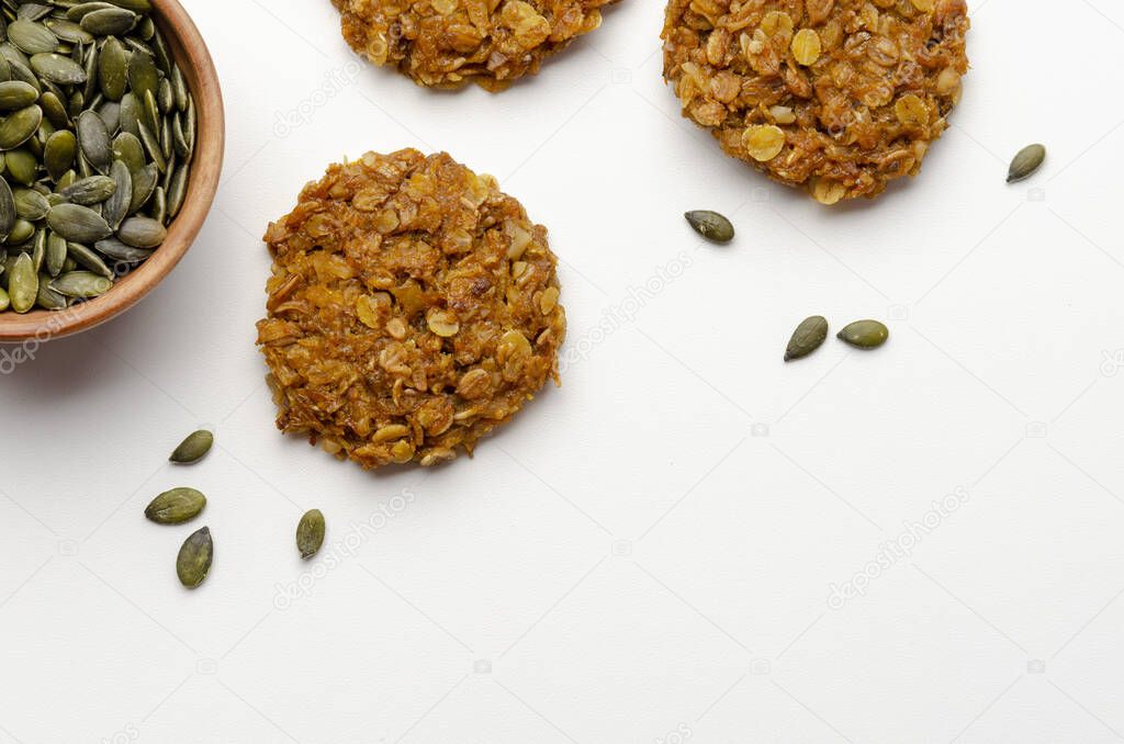 Pumpkin vegan oatmeal cookies with nuts on white background