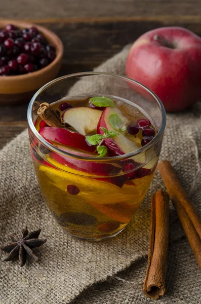 Spiced apple mocktail with mint and cinnamon. wooedn background