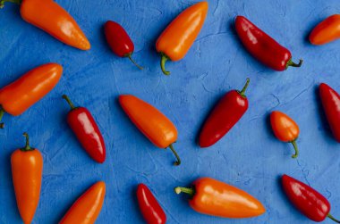 Renkli arka planda kırmızı ve turuncu biberler izole edilmiş