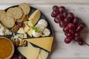 Beyaz arka planda reçelli fındıklı ve kurabiyeli peynir tabağı