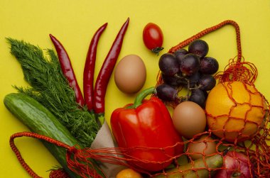 Arka planda farklı yiyeceklerden oluşan ağ torbası. Sıfır atık.