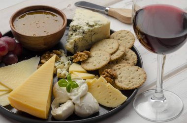 Beyaz arka planda reçelli fındıklı ve kurabiyeli peynir tabağı