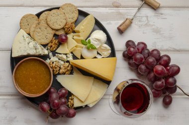 Beyaz arka planda reçelli fındıklı ve kurabiyeli peynir tabağı