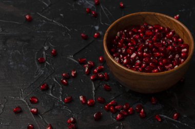 Koyu arkaplanda nar tohumları olan bir kase.