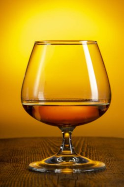 Bir bardak Calvados Brandy ve tahta masada kırmızı elmalar.