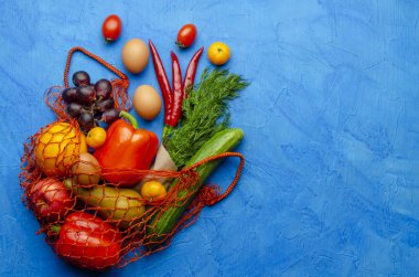 Arka planda farklı yiyeceklerden oluşan ağ torbası. Sıfır atık.