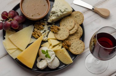 Beyaz arka planda reçelli fındıklı ve kurabiyeli peynir tabağı