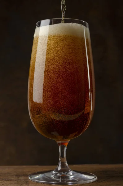 Bier gieten in een glas op de roestachtergrond — Stockfoto
