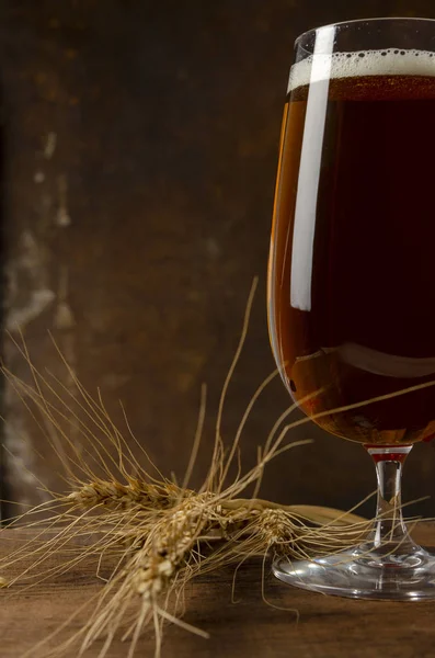 Pivo nalévající se do sklenice na rezavém pozadí — Stock fotografie