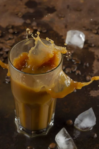 Splash de bebida de café gelado em um fundo marrom. Iatte com gelo . — Fotografia de Stock