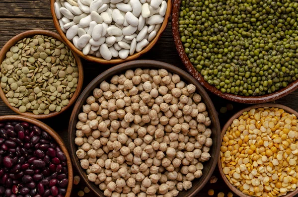 Tazón con frijoles y legumbres sobre fondo de madera viejo — Foto de Stock