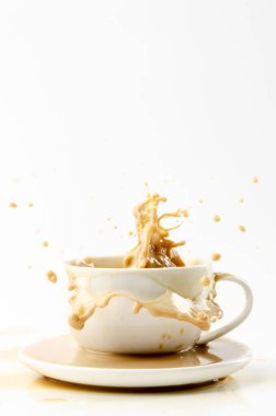 Kahvenin beyaz arka planında kahve sıçraması var.