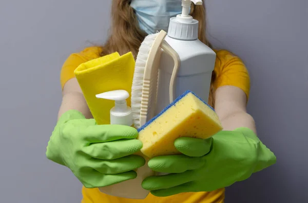 Женщина в медицинской маске и латексных перчатках с чистящими средствами. Пандемия коронного вируса . — стоковое фото