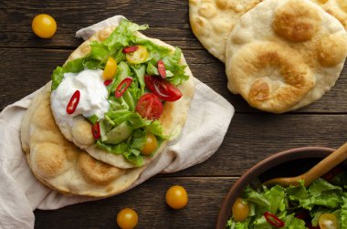 Navajo usulü kızarmış ekmek, yeşil salata ve tahtadan yapılmış yoğurt.