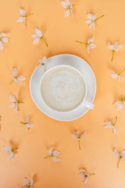 Renkli arka planda beyaz bir fincan kahve, beyaz yay.