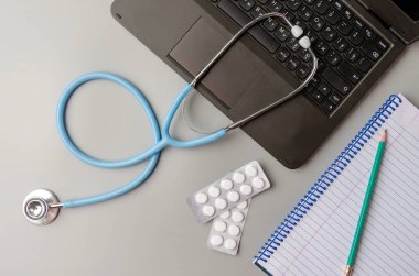 Teletıp ya da tele-sağlık, uzaktan doktor görüntülü sohbet konsepti, dizüstü bilgisayar ve stetoskop gri üzerine
