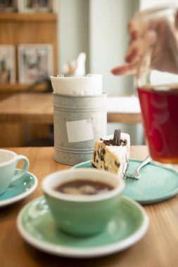 Ahşap masada iki fincan kahve. Kahve evi manzarası, sabah rahatlaması, öğle yemeği. Önplan bulanık.