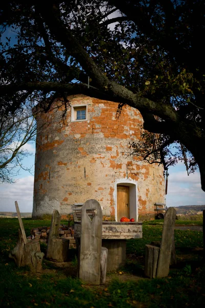 Picnic under a decorated deciduous tree in the background a stone windmill. Sunny autumn day. Czech Republic, Moravia