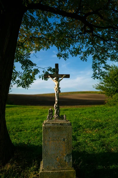 A roadside cross standing by the road among Moravian fields