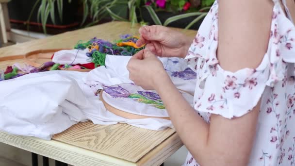 Meisje aan tafel naaien met naald. borduurwerk, borduurwerk, hobby, handwerk — Stockvideo
