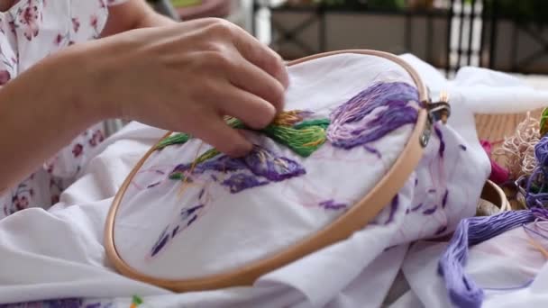 Las manos femeninas jóvenes cosen con aguja. costura, bordado, pasatiempo. Primer plano. — Vídeo de stock