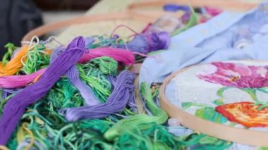 Nakışlı çember, işlemeli kumaş iplikler masa üzerinde renkli desenli.