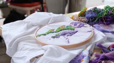 Genç kadın elleri iğneyle dikilir. Dikiş, nakış, hobi. Yakın çekim.