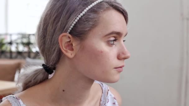 Detailní up na mladé krásné dívky v letních šatech sedí v kavárně a pózování — Stock video