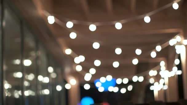 Verschwommene Lichter aus Girlanden auf der Veranda am Abend. Neujahrs- und Weihnachtsstimmung — Stockvideo