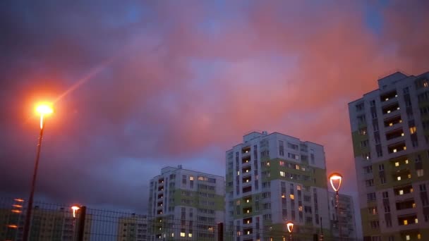 Красочные дома на фоне розового заката в жилом районе вечером — стоковое видео