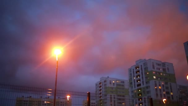 Coloridas casas sobre fondo de rosa puesta de sol en zona residencial por la noche — Vídeos de Stock