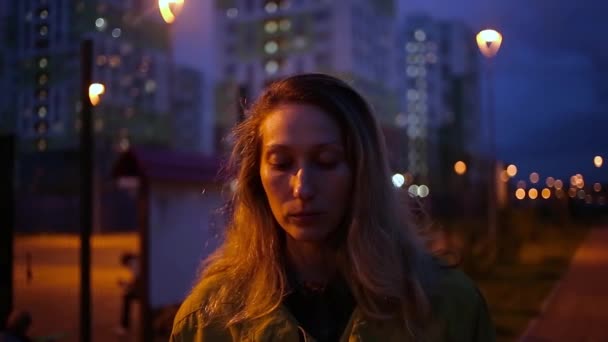 Portrét přemýšlivé bělošky venku s nočními městskými světly boke — Stock video