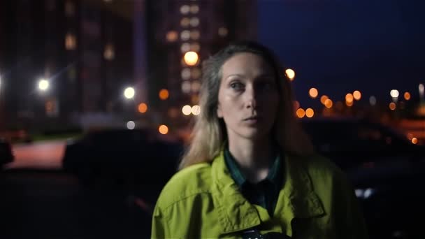 Kavkazská žena zamyšleně narovnává vlasy venku s nočním světlem města — Stock video