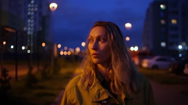 Portrét přemýšlivé bělošky venku s nočními městskými světly boke — Stock video