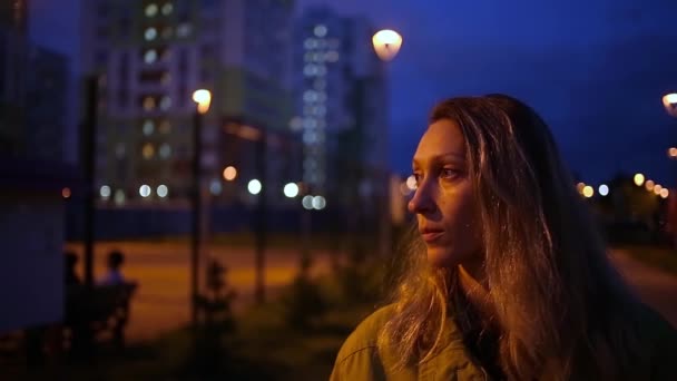 Portrait of thoughtful caucasian woman outdoors with night city lights boke — Stock Video