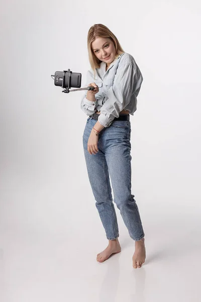 Mutlu genç kız, selfie çubuğuna bağlı akıllı telefonuyla kendi portresini yapıyor. — Stok fotoğraf
