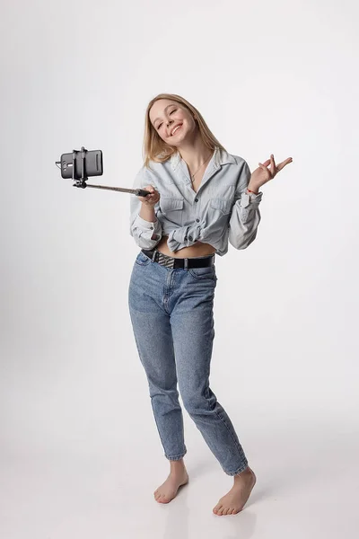 Mutlu genç kız, selfie çubuğuna bağlı akıllı telefonuyla kendi portresini yapıyor. — Stok fotoğraf