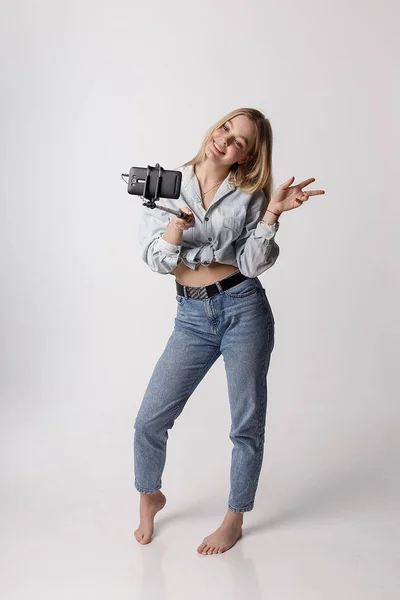 Glückliches junges Mädchen macht Selbstporträt mit Smartphone am Selfie-Stick — Stockfoto