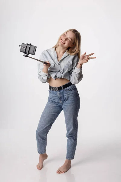 Szczęśliwy młoda dziewczyna co autoportret ze smartfonem dołączony do selfie stick — Zdjęcie stockowe