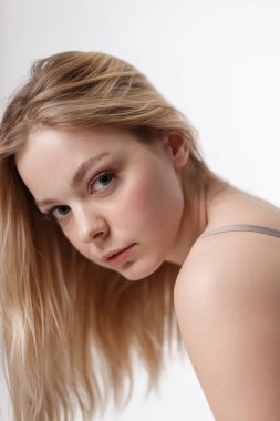 Çıplak omuzlu beyaz bir kız kameraya bakıyor. Portre, kapat.